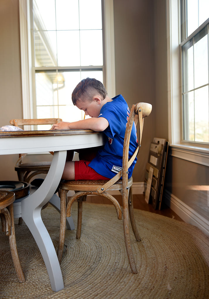 Madden Kurowski, 9, student at Beulah Ralph Elementary School, works on his school packet at the breakfast table